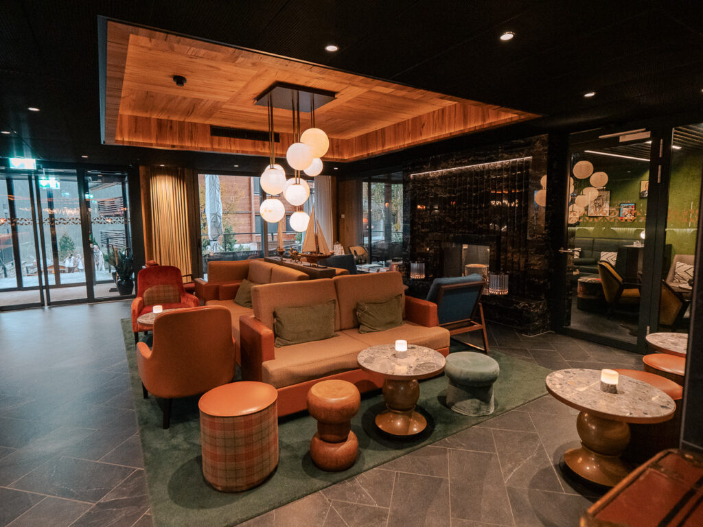 Bergwelt Grindelwald hotel lobby with modern interiors, warm wood panelling, and moody ambient lighting
