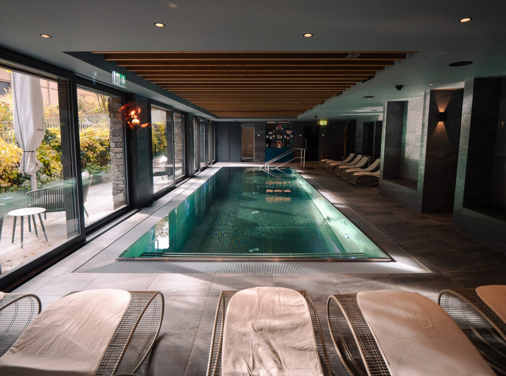 Bergwelt Grindelwald hotel indoor pool with atmospheric low lighting and stone-toned surroundings