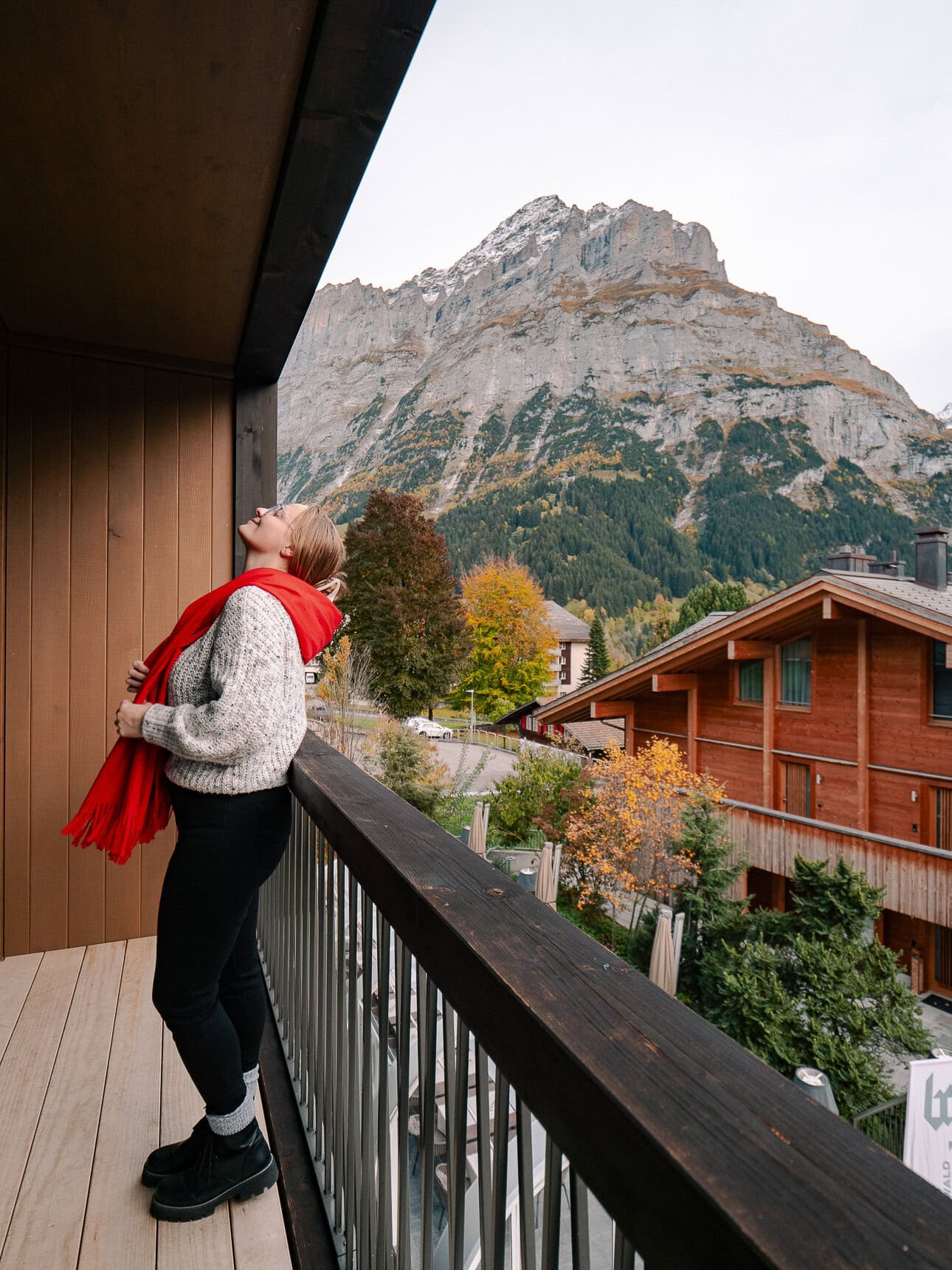 Me standing on a Bergwelt Grindelwald balcony with my back to the camera, looking out at the mountains in switzerland
